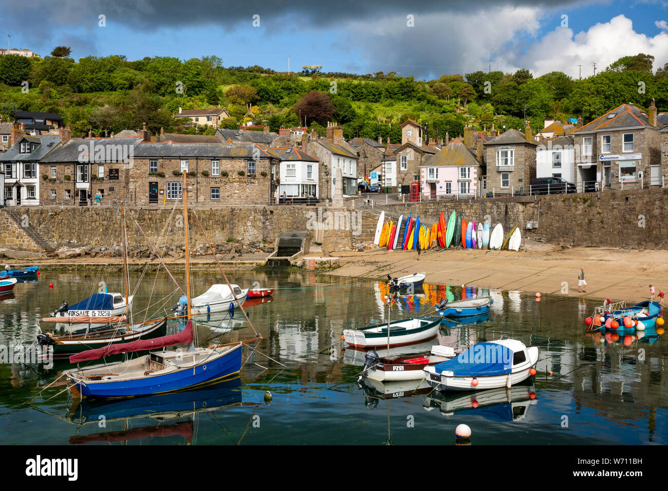 Regno Unito, Inghilterra, Cornwall, Mousehole, barche ormeggiate in porto sotto la spiaggia con la bassa marea Foto Stock