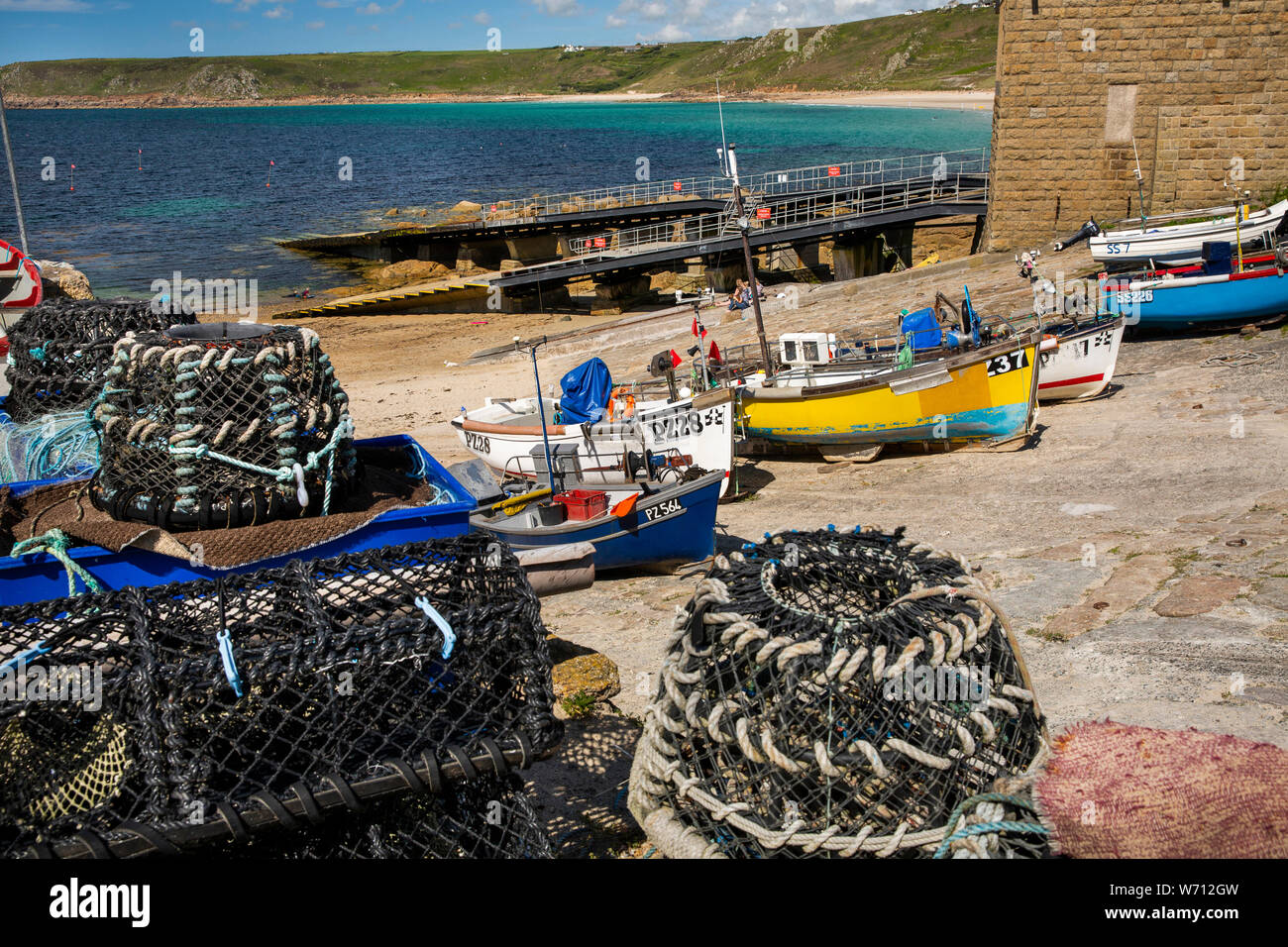 Regno Unito, Inghilterra, Cornwall, Sennen Cove, aragosta pentole e barche da pesca accanto RNLI scialuppa di salvataggio di uno scalo stazione Foto Stock