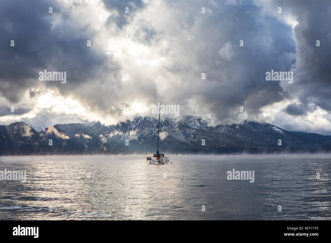 Un solitario barca sul Lago Tahoe dopo una tarda estate tempesta che ha portato la pioggia, vento e neve. Foto Stock