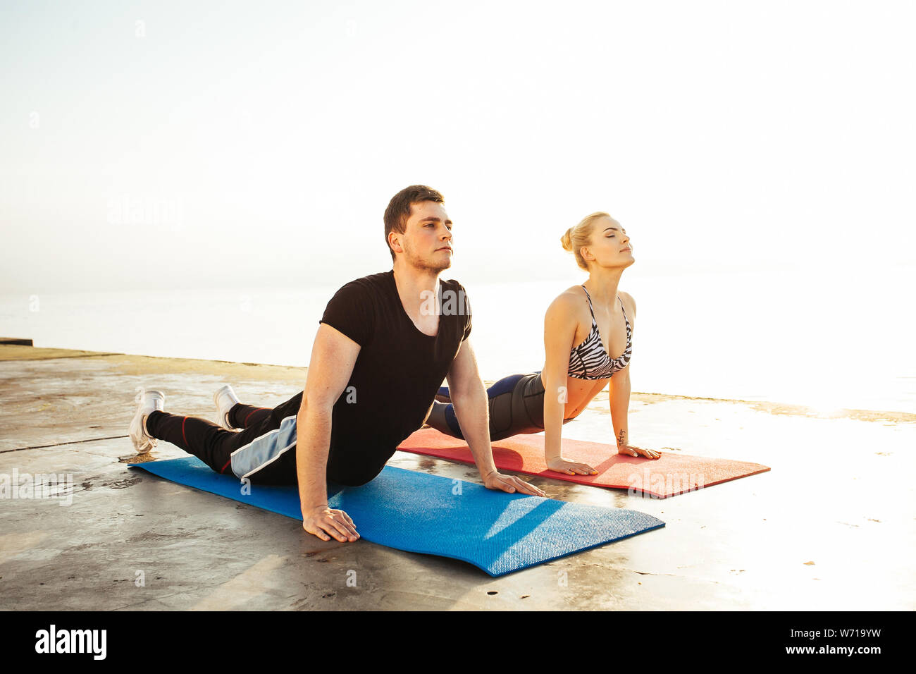 Fitness, sport, amicizia e il concetto di stile di vita - giovane che esercitano in spiaggia Foto Stock