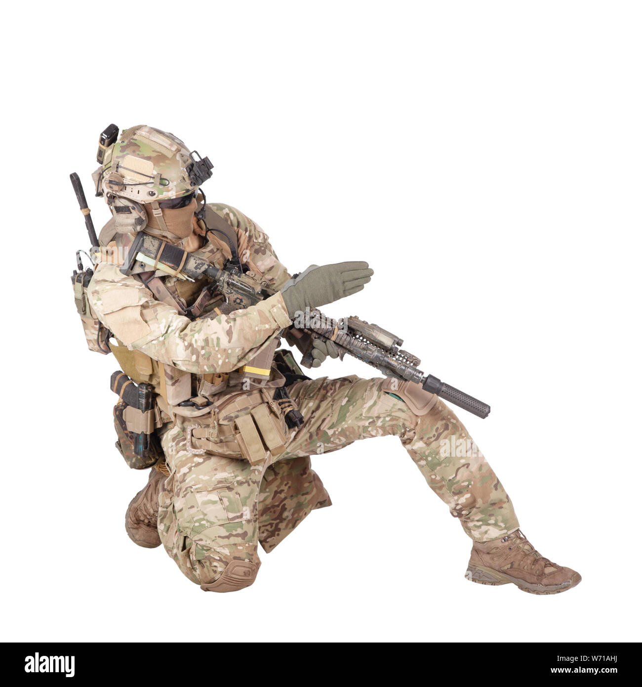 Forze speciali sergente, leader della squadra di battaglia in uniforme camo, casco con cuffie radio, fucile armato in piedi sul ginocchio, direzione di puntamento, dando ordini ai compagni di studio sparare isolato su bianco Foto Stock