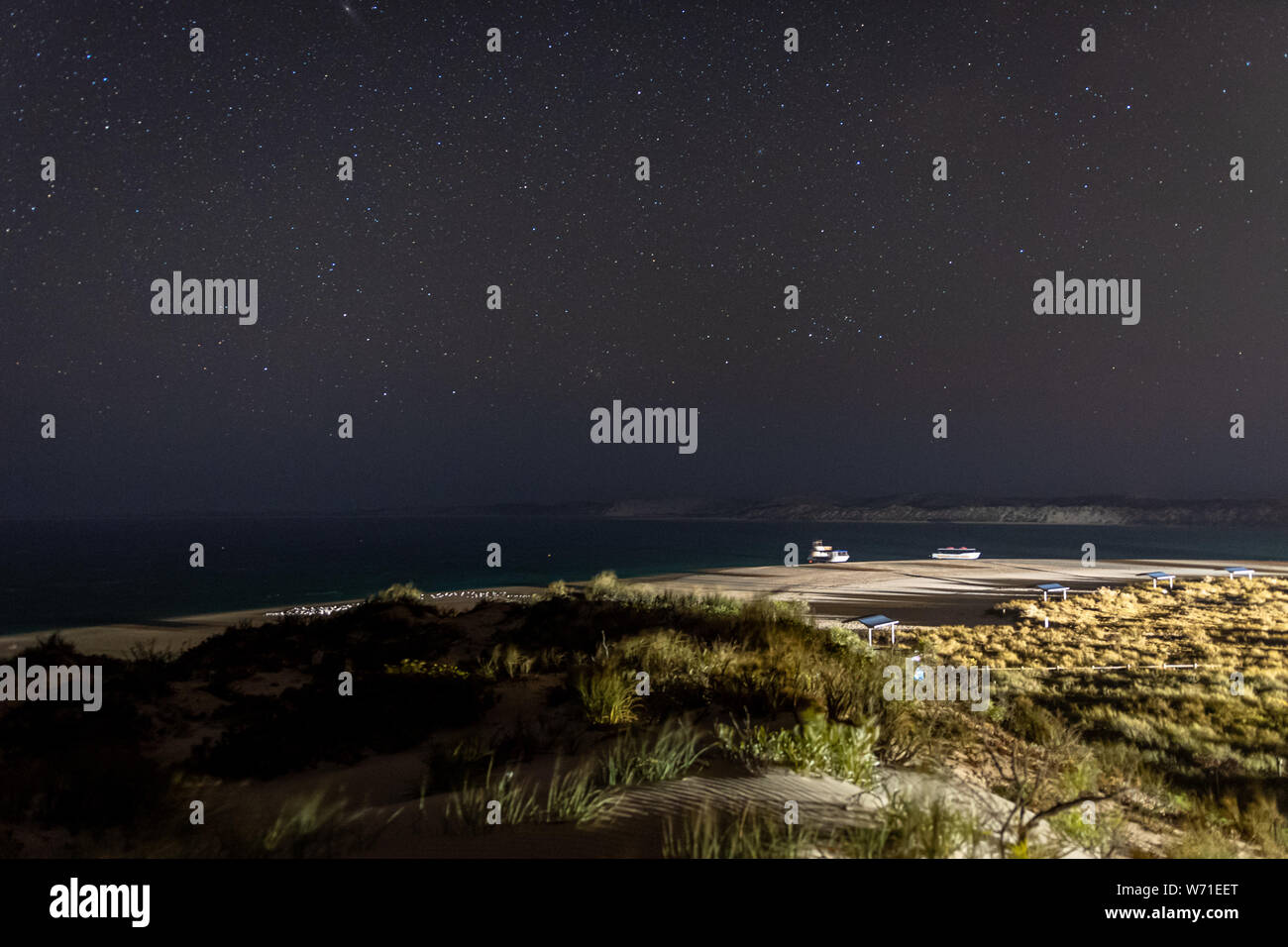 Luci luminose di Coral Bay durante la notte nella parte anteriore del cielo notturno in Australia Foto Stock