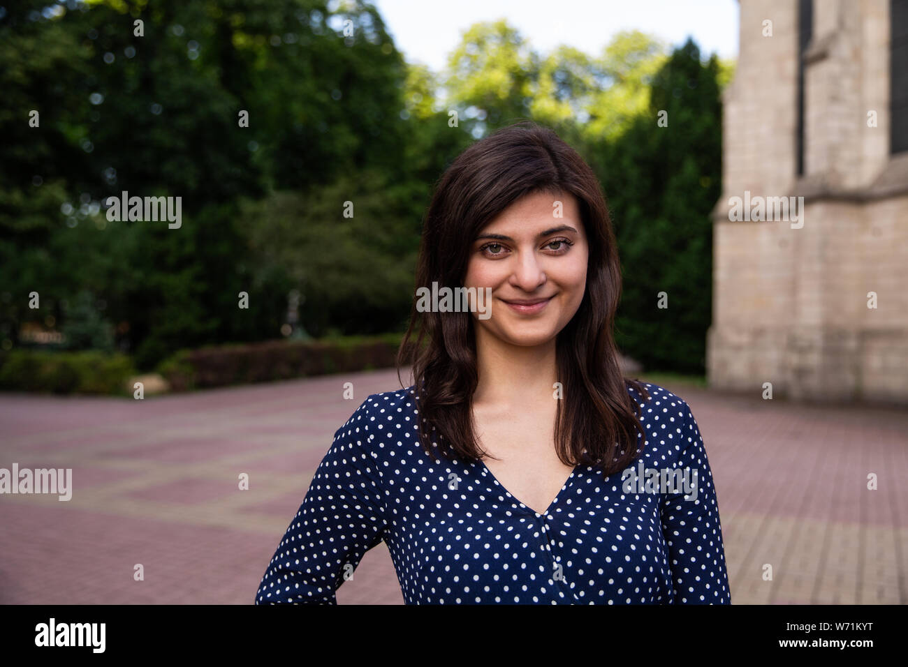 Stupendo giovane donna in piedi all'aperto nella città e guardando la fotocamera Foto Stock