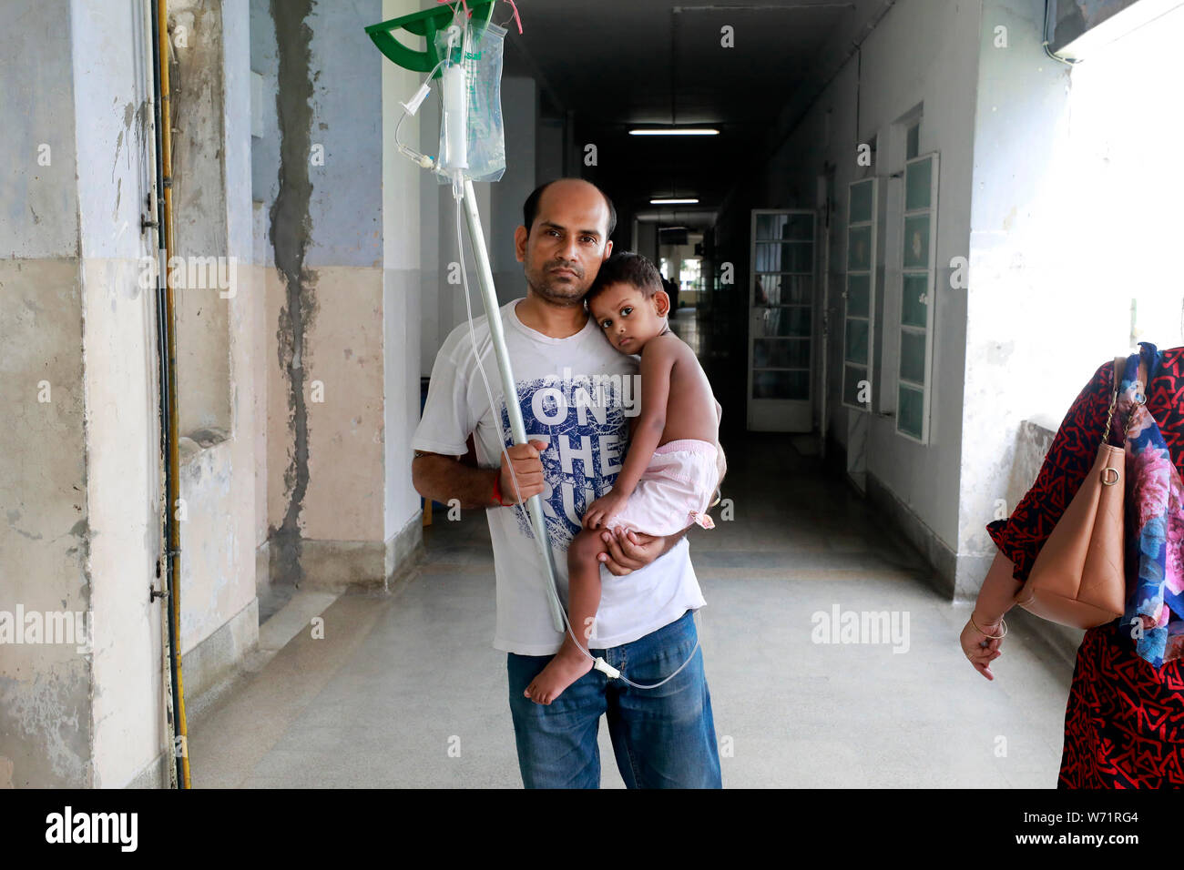 Dacca in Bangladesh - Agosto 04, 2019: il padre coccole a cinque anni paziente dengue nei locali della Santa Famiglia Red Crescent Medical College Hos Foto Stock