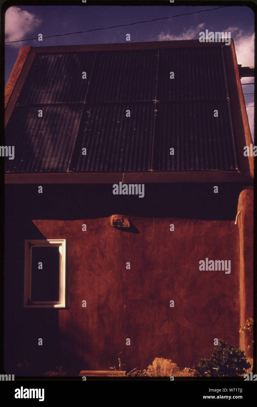 ADOBE HOUSE si trova a Santa Fe, New Mexico, convertito per il riscaldamento da energia solare. All'interno di vetro ricoperta di pannelli sul tetto aria forzata che passa sopra la annerito superficie in metallo ed è riscaldata a circa due tonnellate di rocce sotto la casa di immagazzinare energia per uso successivo Foto Stock