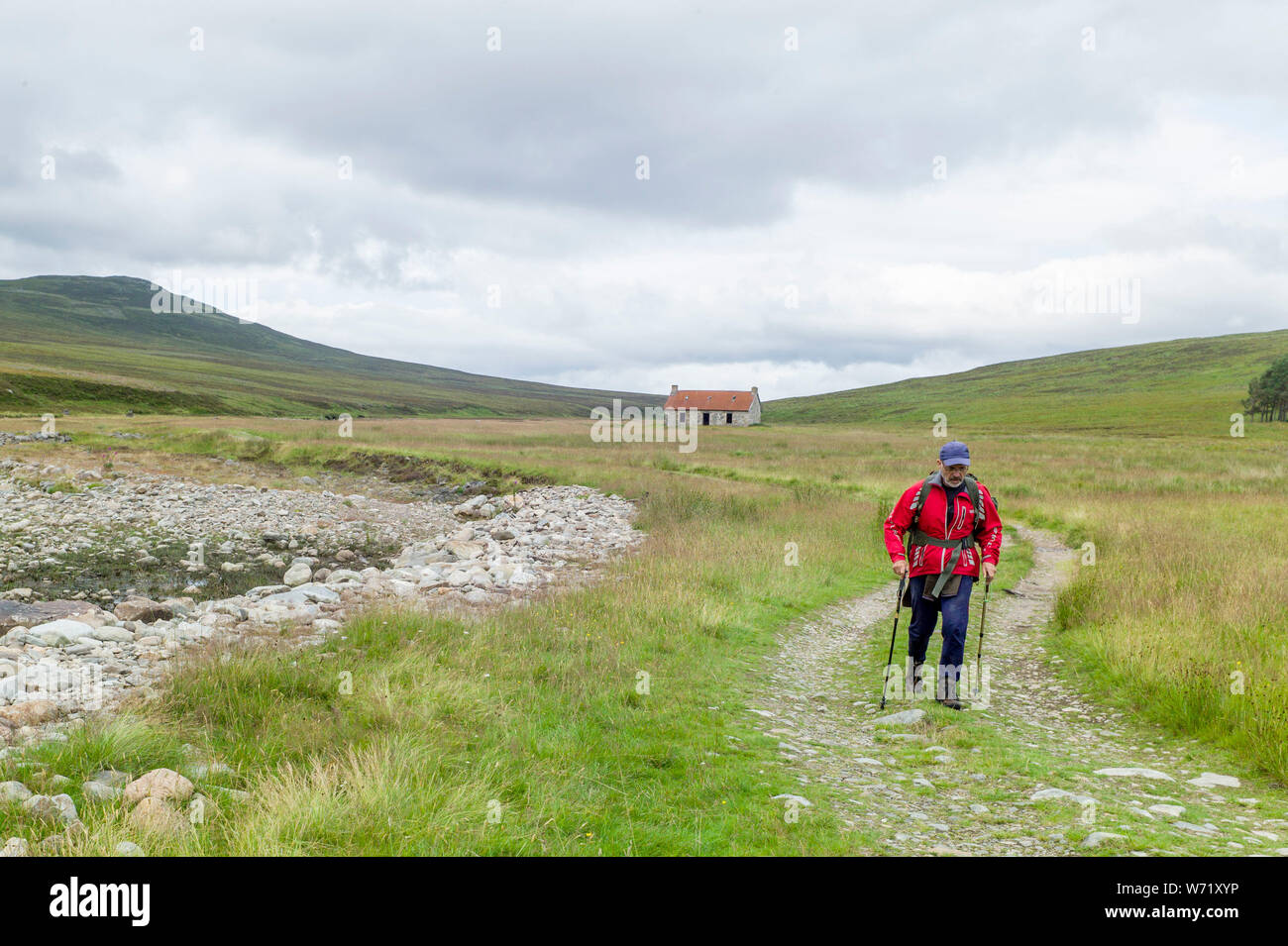 Un viandante accanto al Geldie masterizzare, Marr Lodge Estate, Braemar, Scozia Foto Stock