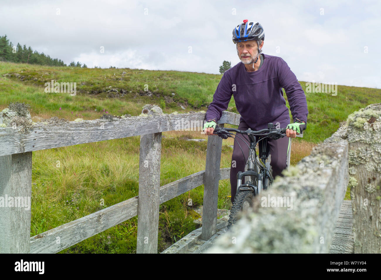 Mountain Biker su un ponte dal Geldie bruciare nella valle tra Marr Lodge e Glenfieshie estates. Scozia Foto Stock