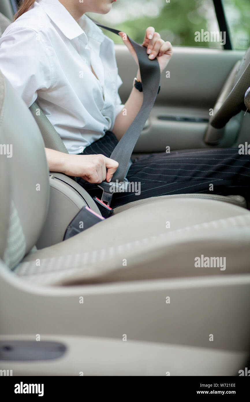 Le donne la mano allaccia la cintura di sicurezza dell'auto. Chiudere la  vostra auto cintura di sicurezza durante la seduta dentro la macchina prima  di prendere e guidare un viaggio sicuro. Primo