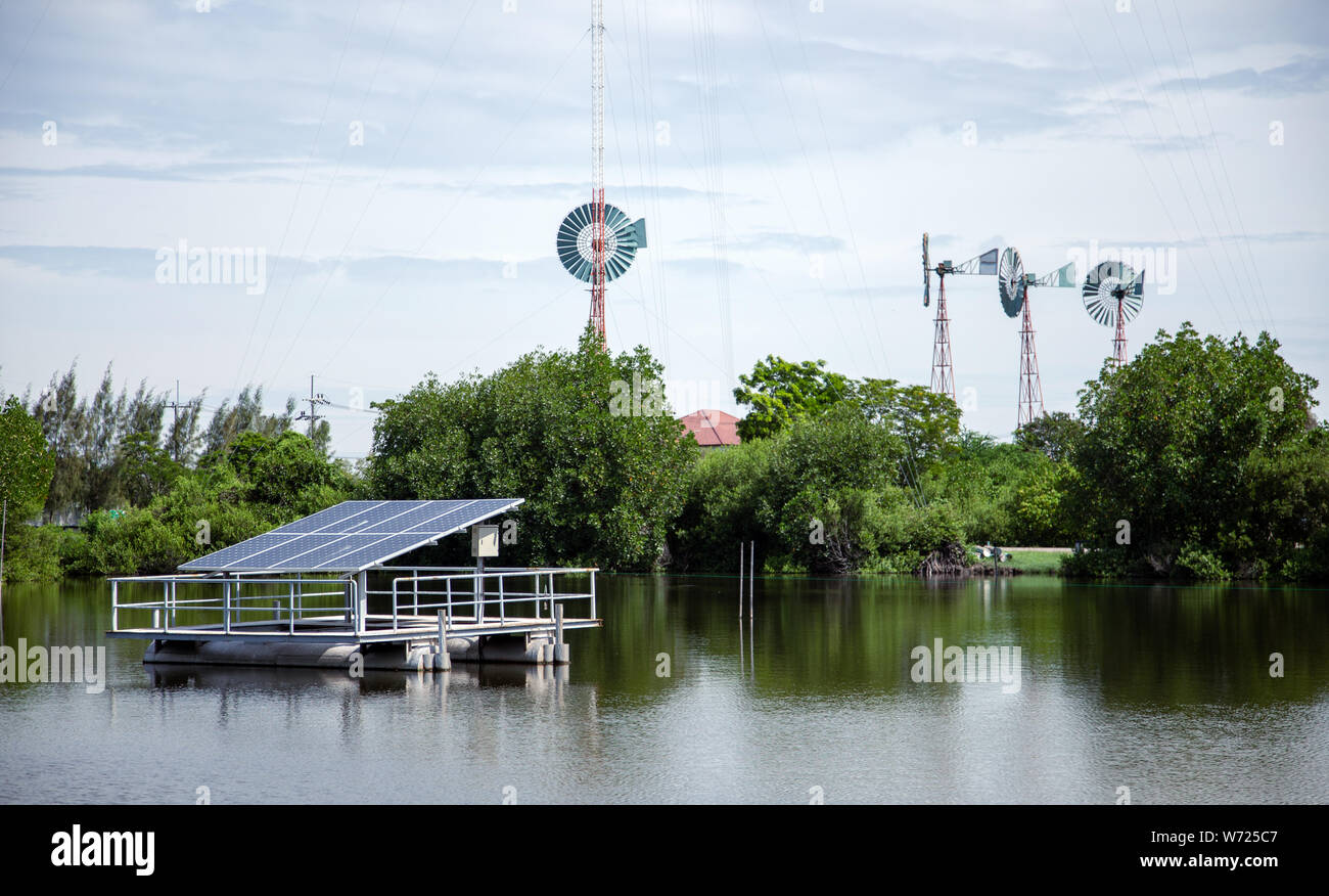 Green power electrict con celle solari e la turbina eolica per generare potenza sul laghetto di acqua Foto Stock