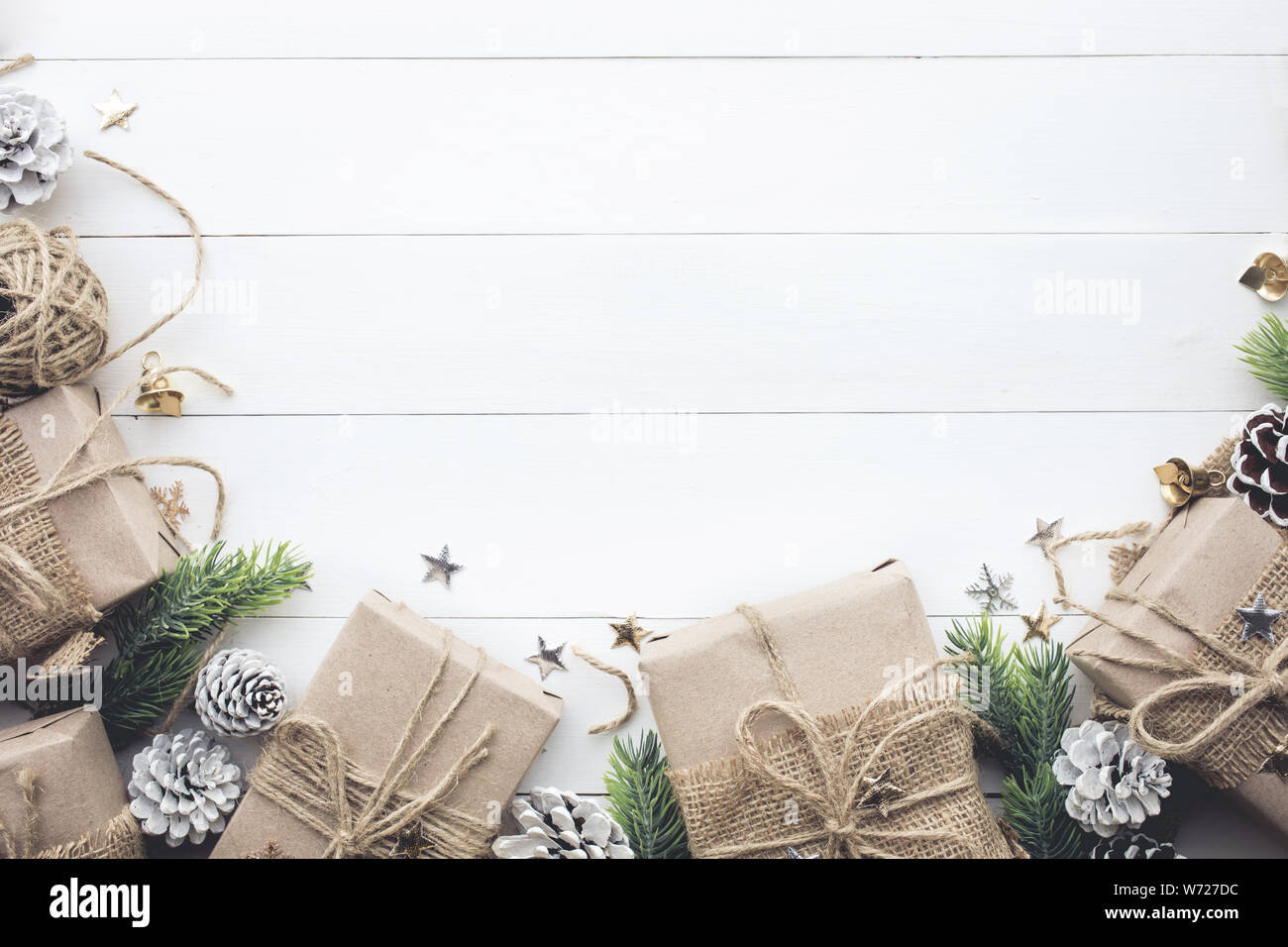 Confezioni regalo collezione avvolti in carta kraft con bordo di pino bianco su uno sfondo di legno.Per natale o nuovi concetti di yew idee.piatto modello laici desig Foto Stock