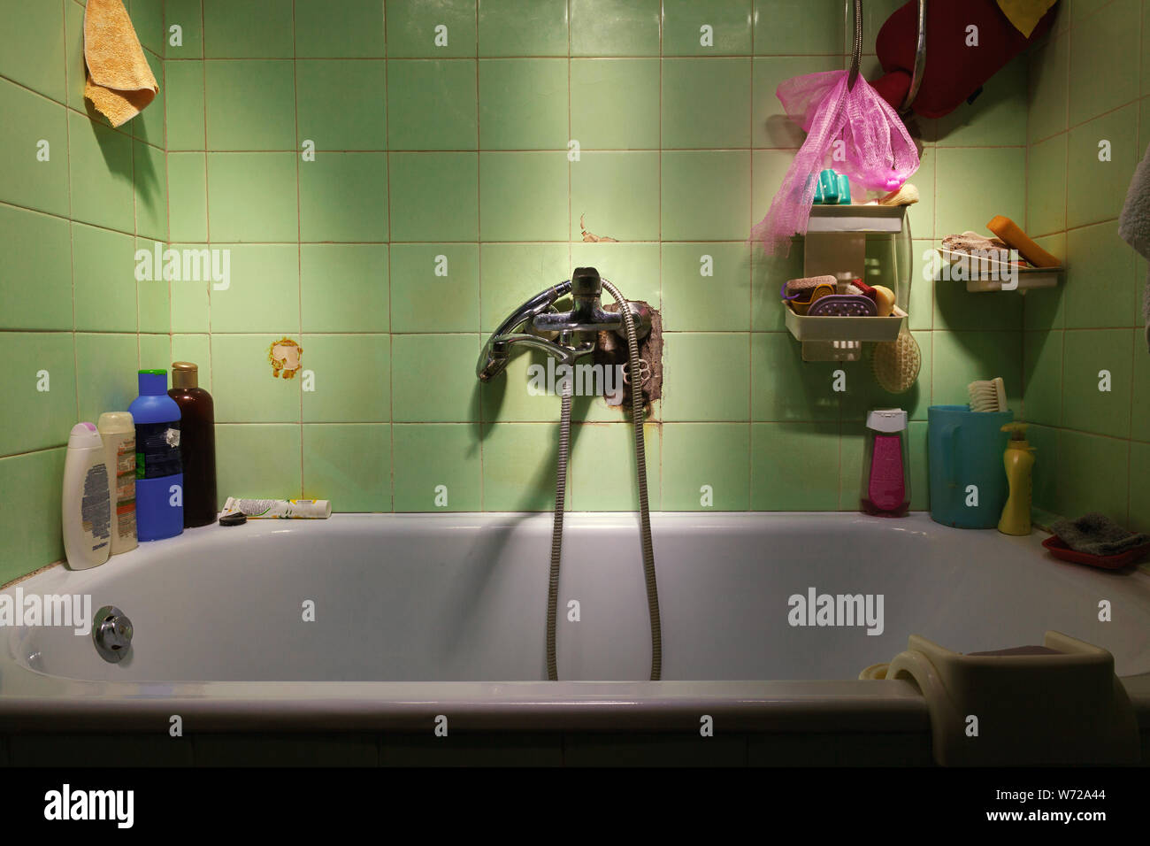 Dettagli di un vecchio bagno, vasca e accessori, sporche e vecchie piastrelle. Foto Stock
