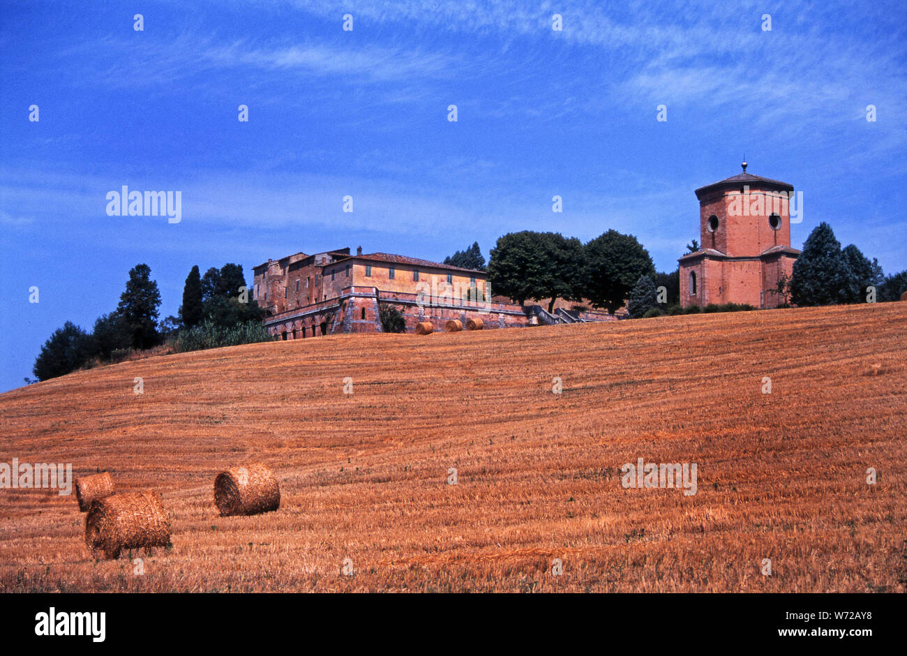 Toscana il paesaggio è noto per le sue colline, delimitate da filari di cipressi corsie, antichi borghi e golden balle di fieno. Foto Stock