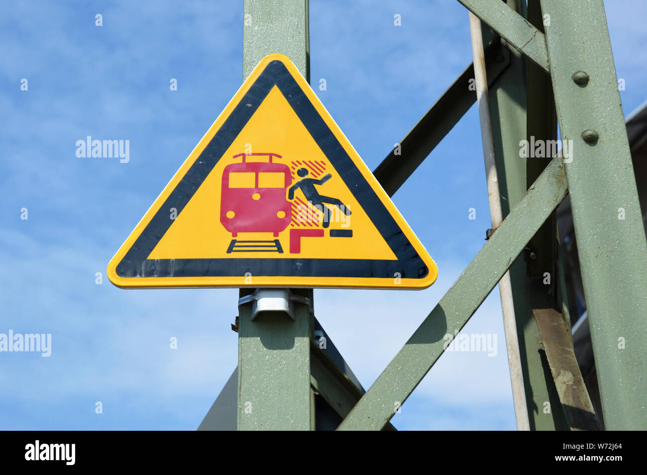 "No a scavalcare la linea rossa' giallo di avvertimento triangolare signn in tedesco stazione ferroviaria mostra stilizzata persona che cade dalla piattaforma Foto Stock