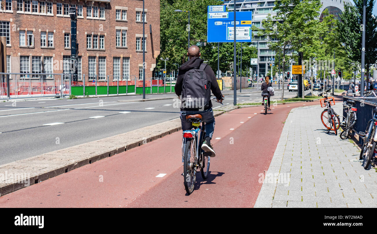 Rotterdam, Paesi Bassi. Giugno 28, 2019. Vista posteriore di persone a cavallo di biciclette in centro città, molla giornata di sole Foto Stock
