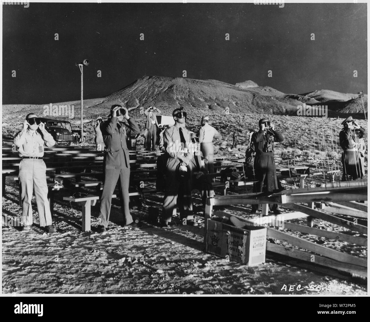 Il Nevada Test Site...i membri del partito del 17 canadese e osservatori del Regno Unito al 400-piedi torre shot in francese di piatto sono mostrati illuminata da entrambi il sole ed il burst Foto Stock