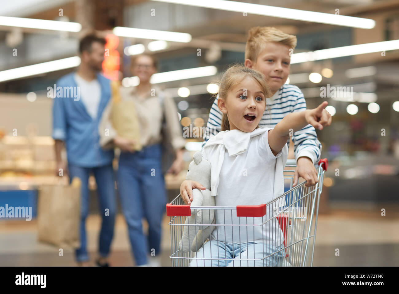 Ritratto di due entusiasti di equitazione per bambini carrello nel supermercato, ritmo di copia Foto Stock