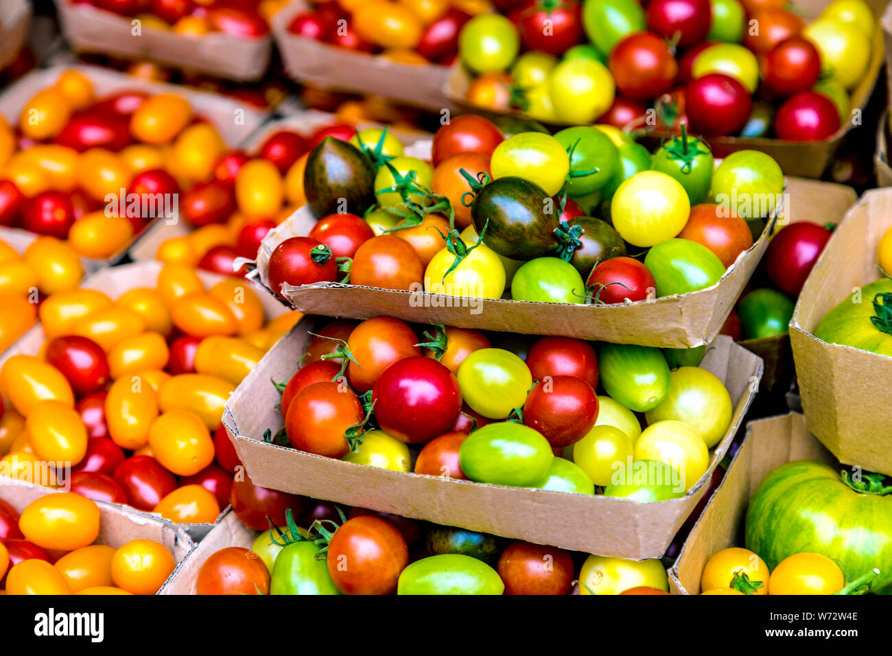 Specialty rosso, giallo e verde i pomodori ciliegia a un mercato agricolo il Victoria Park Market, London, Regno Unito Foto Stock