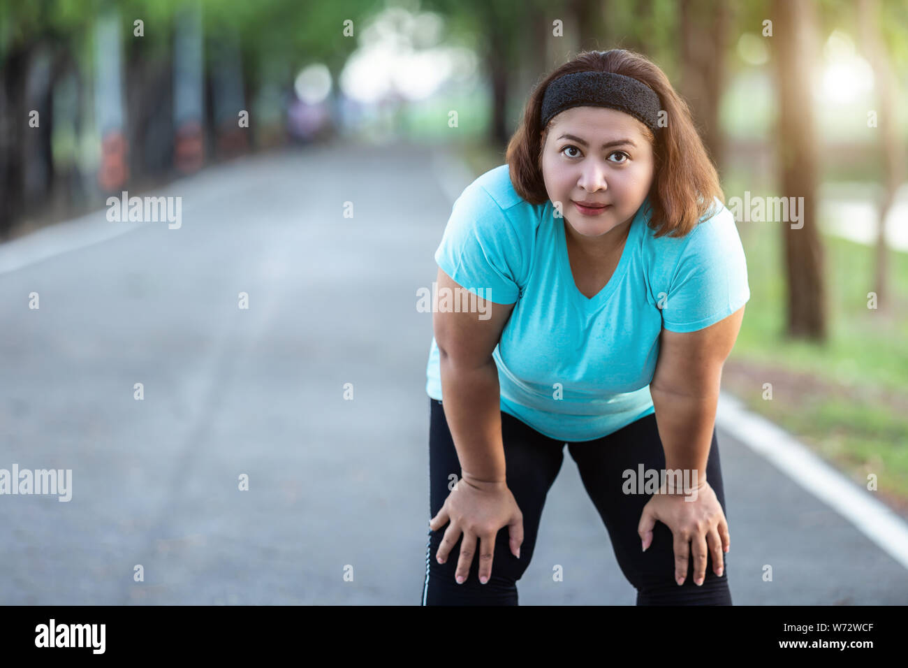 Esercizio e un sano concetto : donna grassa sensazione di stanchezza mentre è in esecuzione il parco Foto Stock
