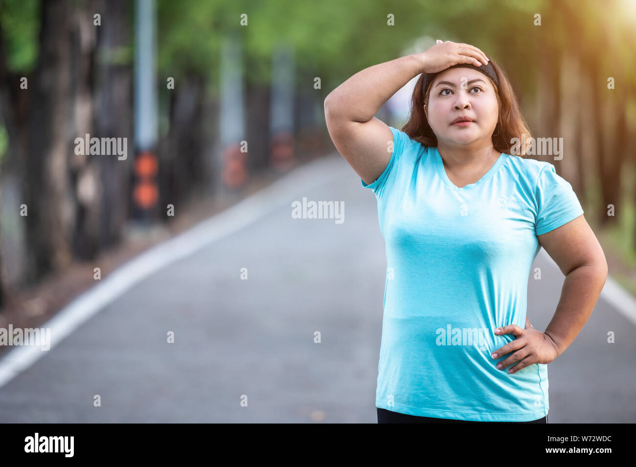 Esercizio e un sano concetto : donna grassa sensazione di stanchezza mentre è in esecuzione il parco Foto Stock