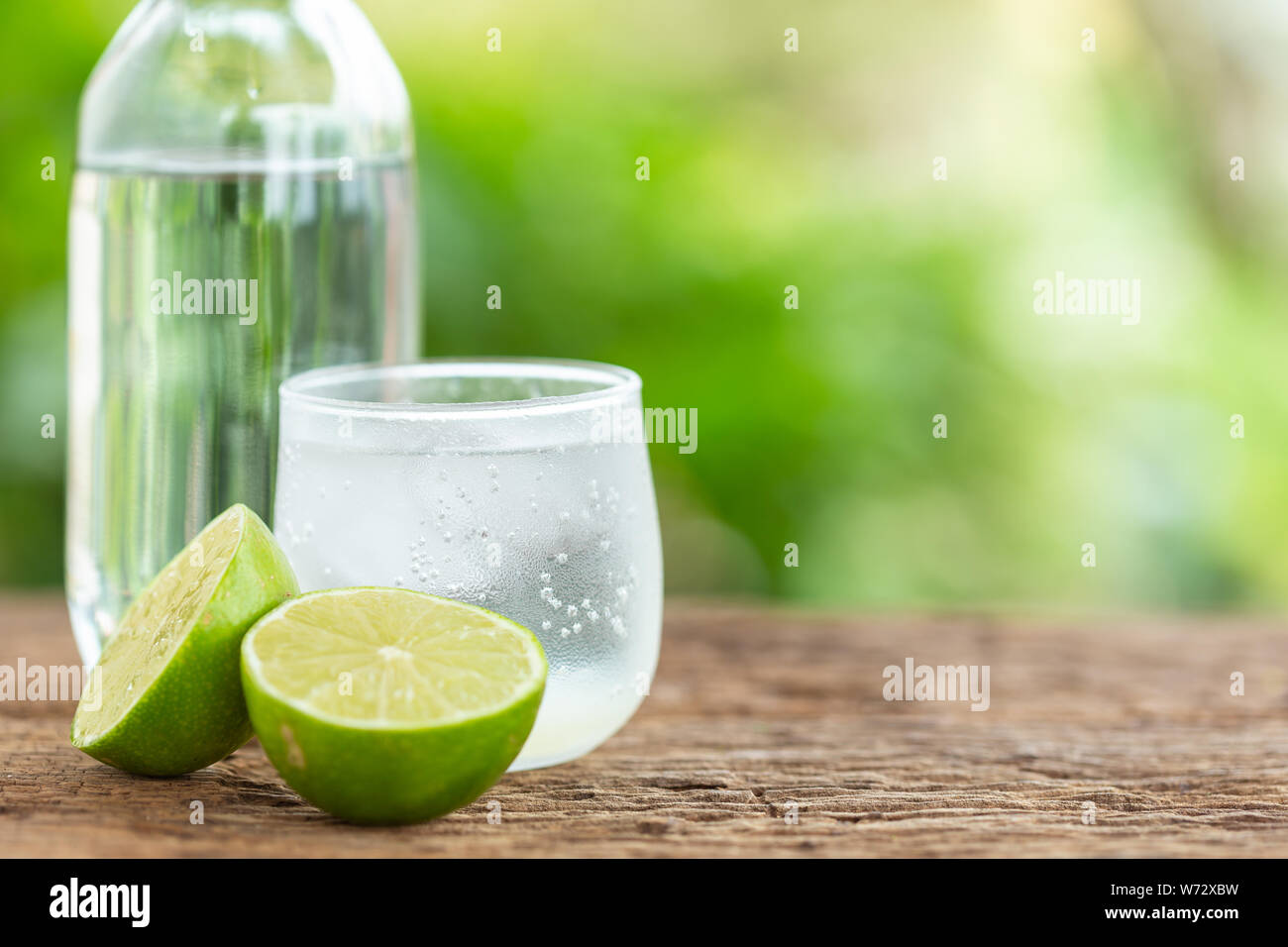 Close-up di vetro ghiacciato soda limone sul tavolo di legno con sfumatura verde spazio per il testo o per la progettazione Foto Stock