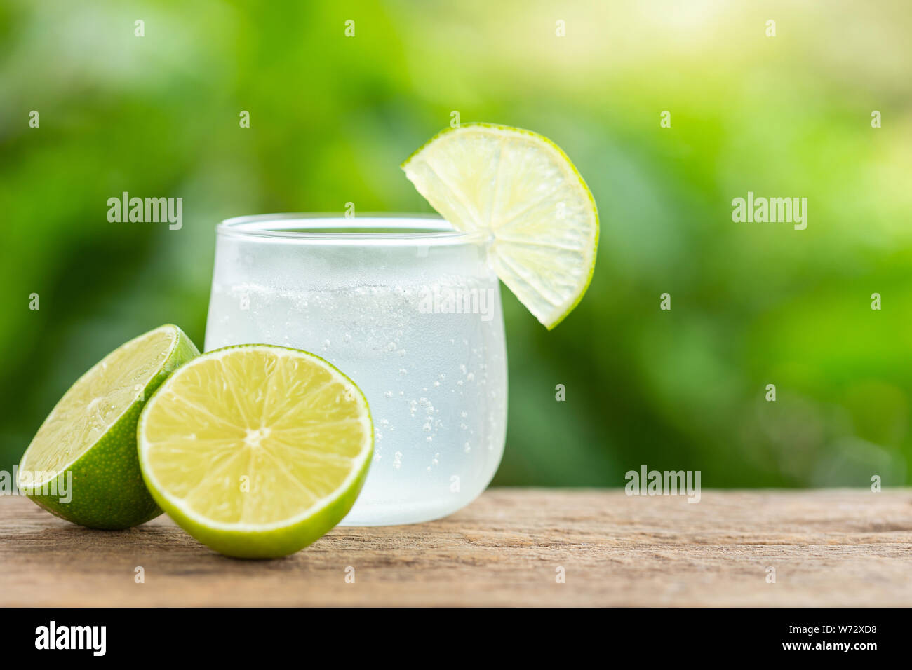 Close-up di vetro ghiacciato soda limone sul tavolo di legno con sfumatura verde spazio per il testo o per la progettazione Foto Stock