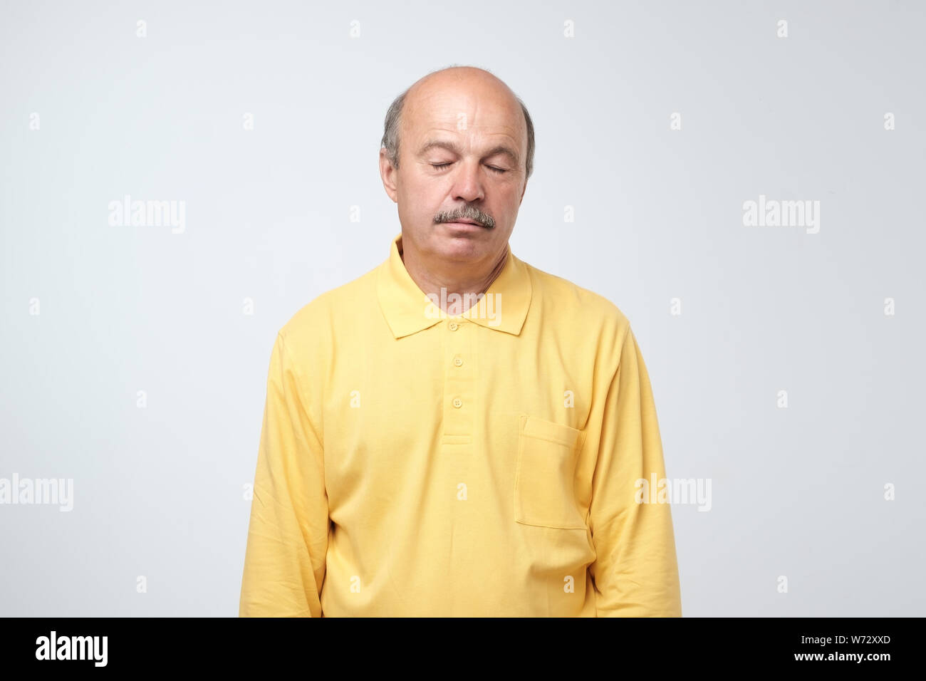 Stanco uomo ispanico in abiti di colore giallo è esaurito. Egli è stanco di ascoltare la sua moglie in chat. Studio shot Foto Stock Stanco uomo ispanico in abiti di colore giallo è esaurito. Egli è stanco di ascoltare la sua moglie in chat. Studio shot Foto Stock