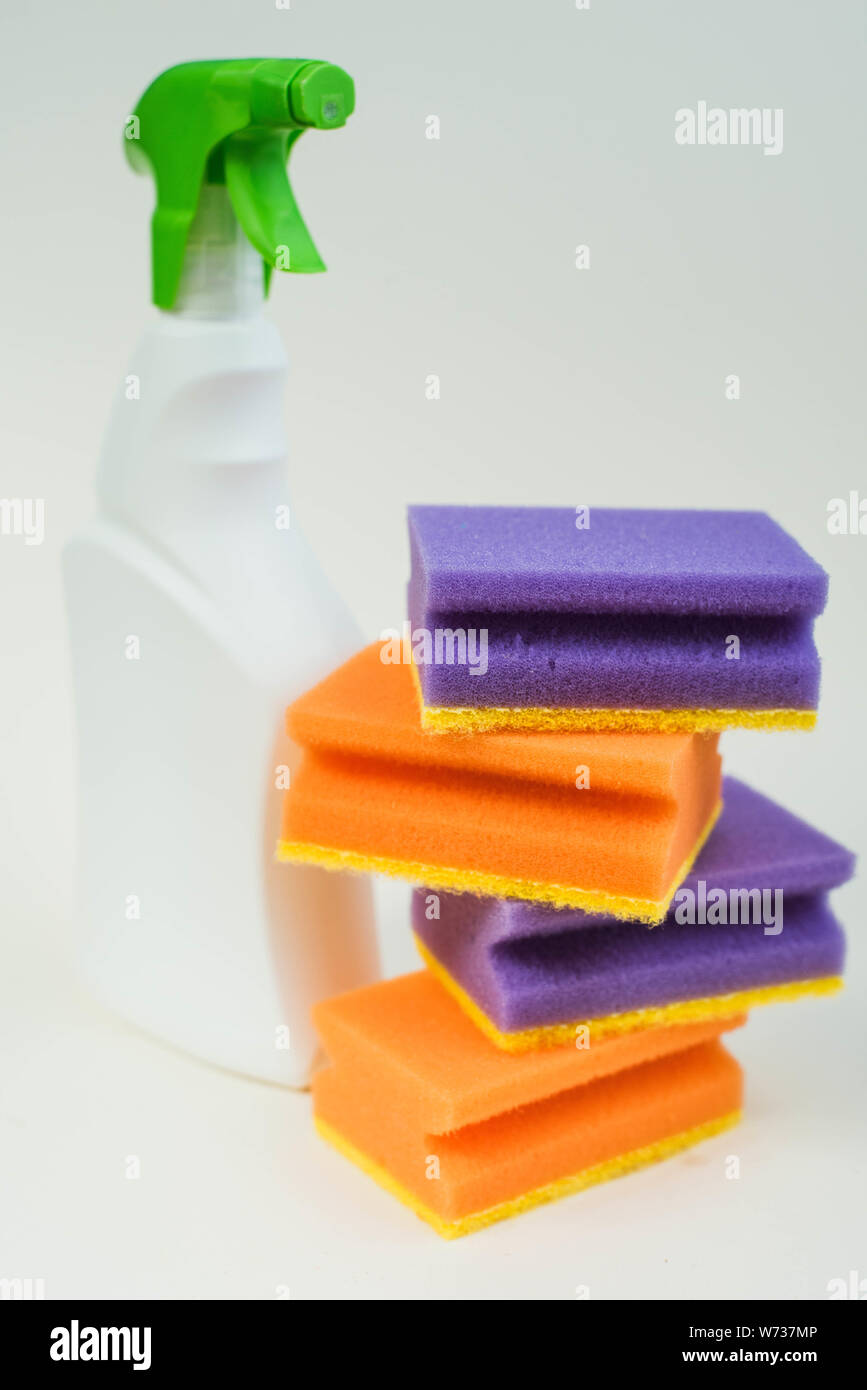 Agente di pulizia e multi-spugne colorate su sfondo bianco. Concetto di faccende di casa Foto Stock
