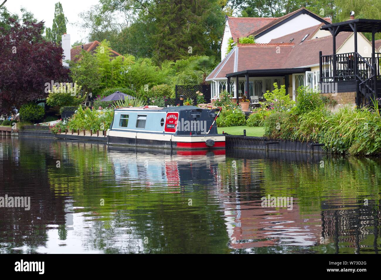 3 agosto 2019 - Harefield, Inghilterra: Canal con casa e barca riflessa nell'acqua Foto Stock