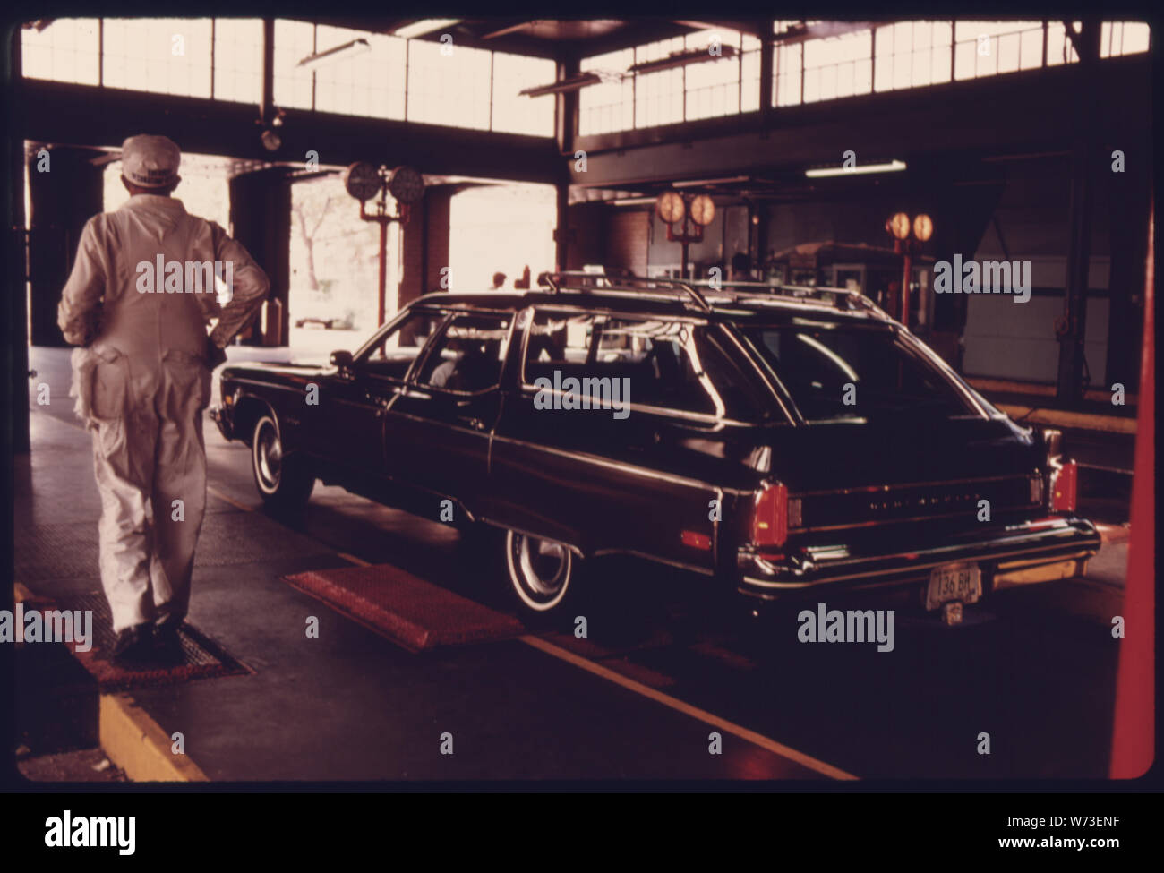 WORKMAN segue la sua stazione carro durante il test a una emissione automatica stazione di ispezione nel centro cittadino di Cincinnati, Ohio. A PARTIRE DAL GENNAIO 1975, TUTTI GLI IMPIEGHI LEGGERI, accensione a scintilla POWERED VEICOLI A MOTORE DEVE ESSERE CONTROLLATO ANNUALMENTE PER IL MONOSSIDO DI CARBONIO E LE EMISSIONI DI IDROCARBURI E DATO UN CONTROLLO DI SICUREZZA. Tutti gli altri veicoli immatricolati nella città devono essere sottoposti annualmente ad un controllo di sicurezza. Il controllo di sicurezza era stato un semi-evento annuale FINO A QUANDO L' AGGIUNTA DI TEST DELLE EMISSIONI Foto Stock