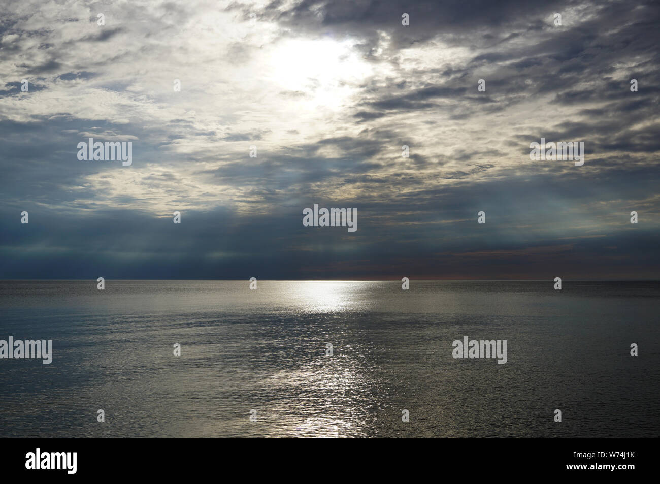 Cielo di tramonto sul mare. La luce del sole rende il suo modo attraverso le nuvole e il sole splende sopra la superficie dell'acqua. Lago di Michig Foto Stock