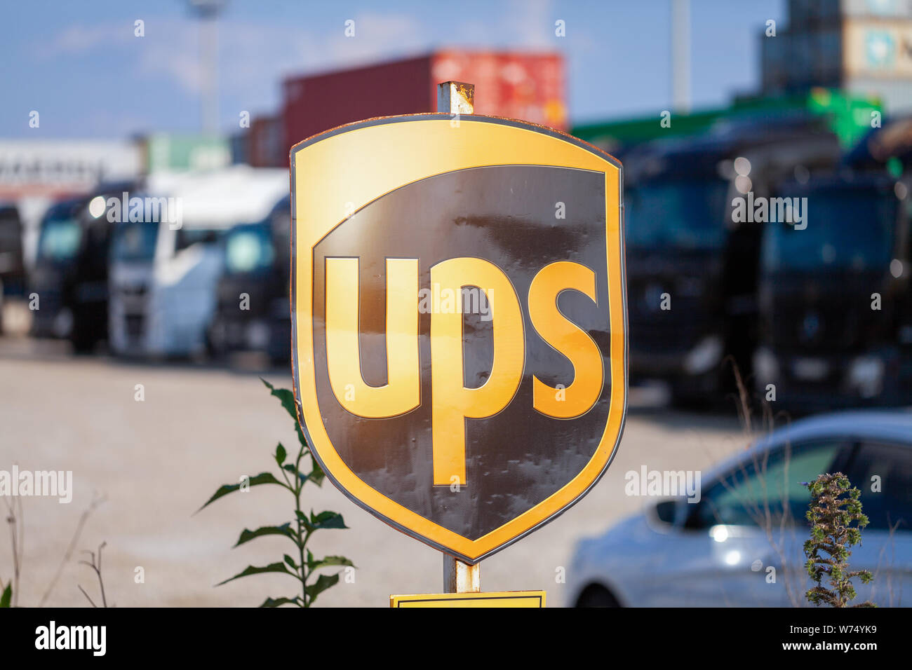 Norimberga / GERMANIA - Agosto 4, 2019: Società segno dalla multinazionale americana di consegna del pacchetto, United Parcel Service (UPS), sorge nei pressi di containe Foto Stock