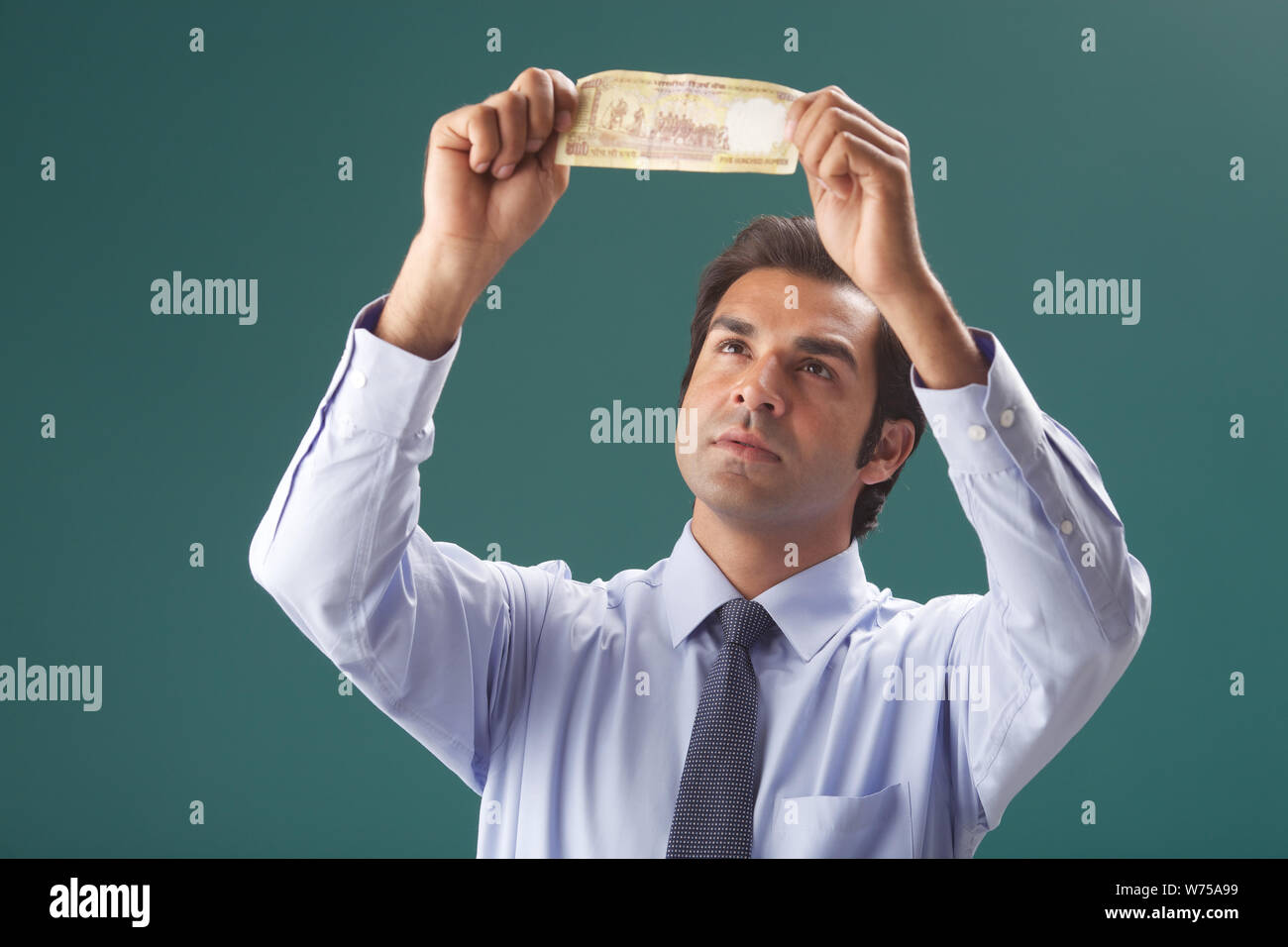 Imprenditore esaminando una cinquecento di rupie banconota Foto Stock