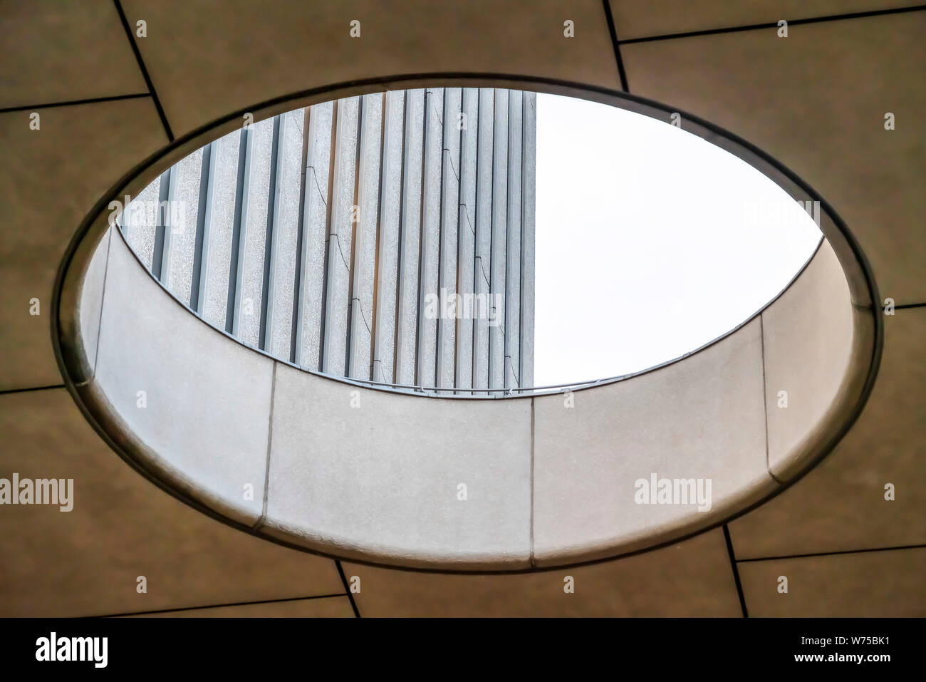 Chiusura del lucernario circolare con vista dell'edificio in cemento di parete esterna Foto Stock