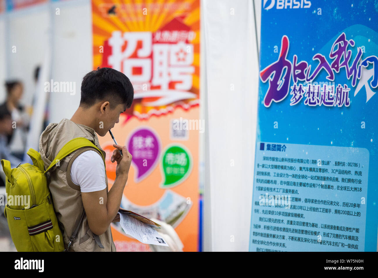 --FILE--un cinese laureato e job seeker guarda a un annuncio pubblicitario per il reclutamento del personale a una fiera del lavoro nella città di Shenzhen, Cina del sud della provincia di Guangdong, Foto Stock