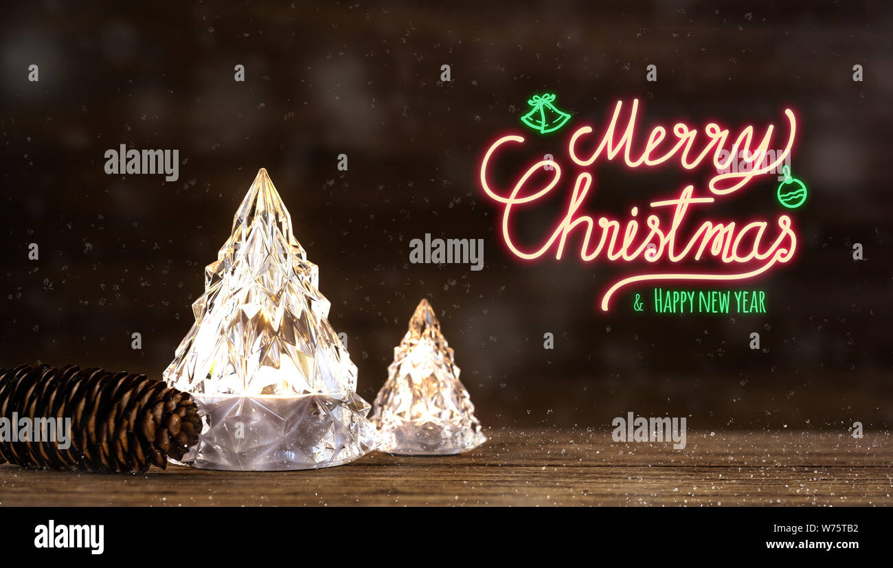 Buon Natale e felice anno nuovo segno al neon con vetro moderno albero di Natale con le luci sul legno scuro tavolo con parete per celebrare il messaggio di saluto festivo Foto Stock