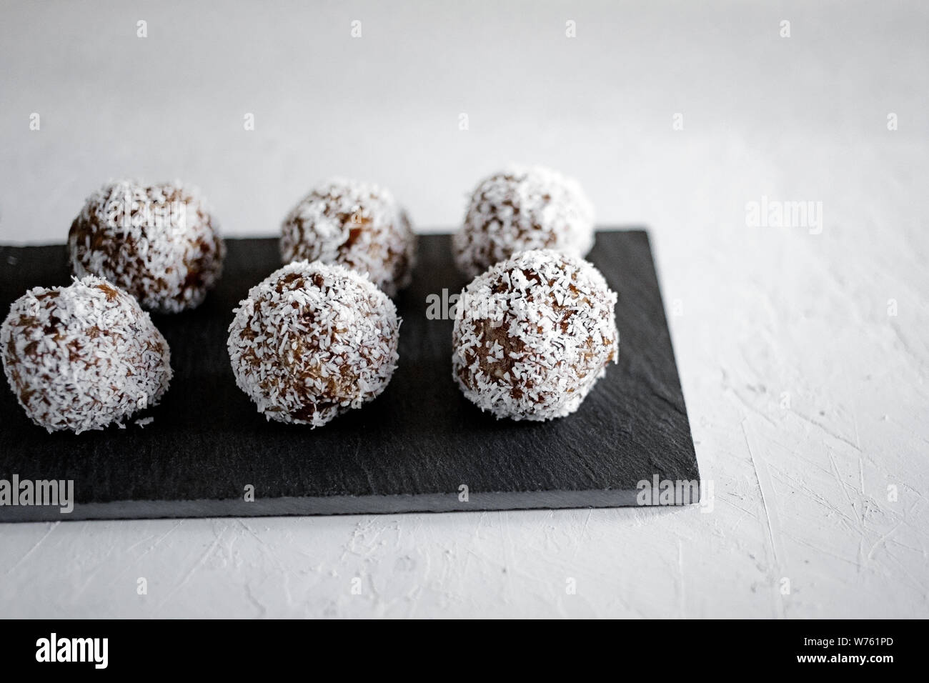 Palle di energia fatte in casa con cocco. Cibo sano per bambini e vegani, sostituto dolci. Sfere sane di energia organica fatte con date, prugne. Foto Stock