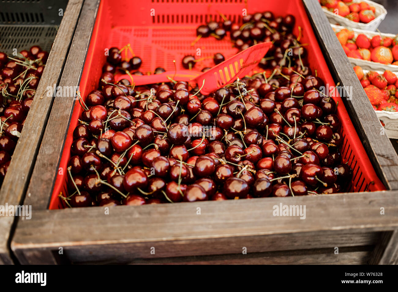 Dolce di ciliegie fresche nelle caselle in un mercato. Fresh ciliegio dolce texture, carta da parati e background. Estate cibo o mercato locale produrre concetto. Foto Stock