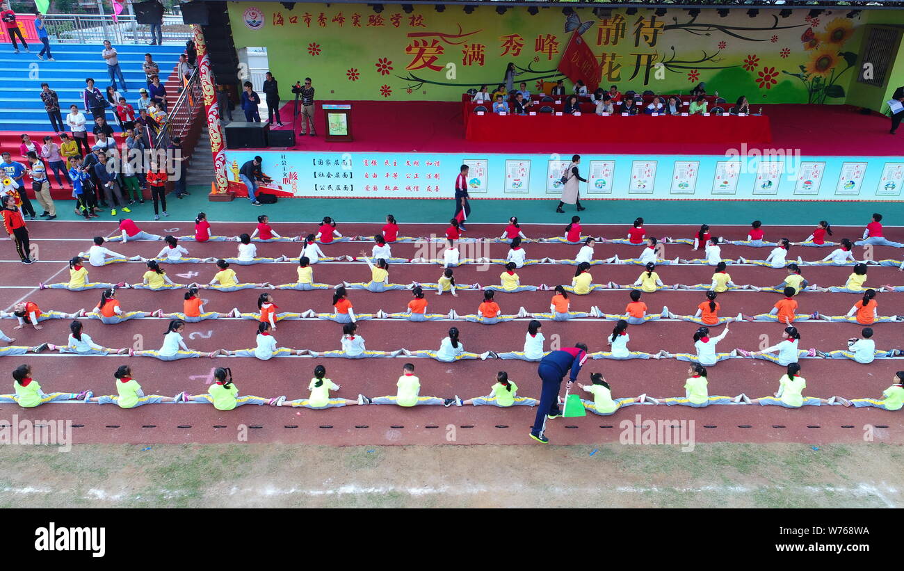 Sei gruppi di studenti fare lo divide per collegare insieme in forma di corde in una competizione durante un incontro sportivo nel centro della città di Haikou, sud della Cina di Foto Stock