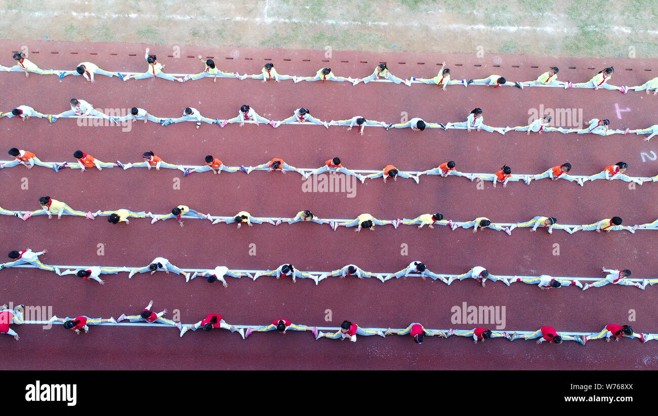 Sei gruppi di studenti fare lo divide per collegare insieme in forma di corde in una competizione durante un incontro sportivo nel centro della città di Haikou, sud della Cina di Foto Stock