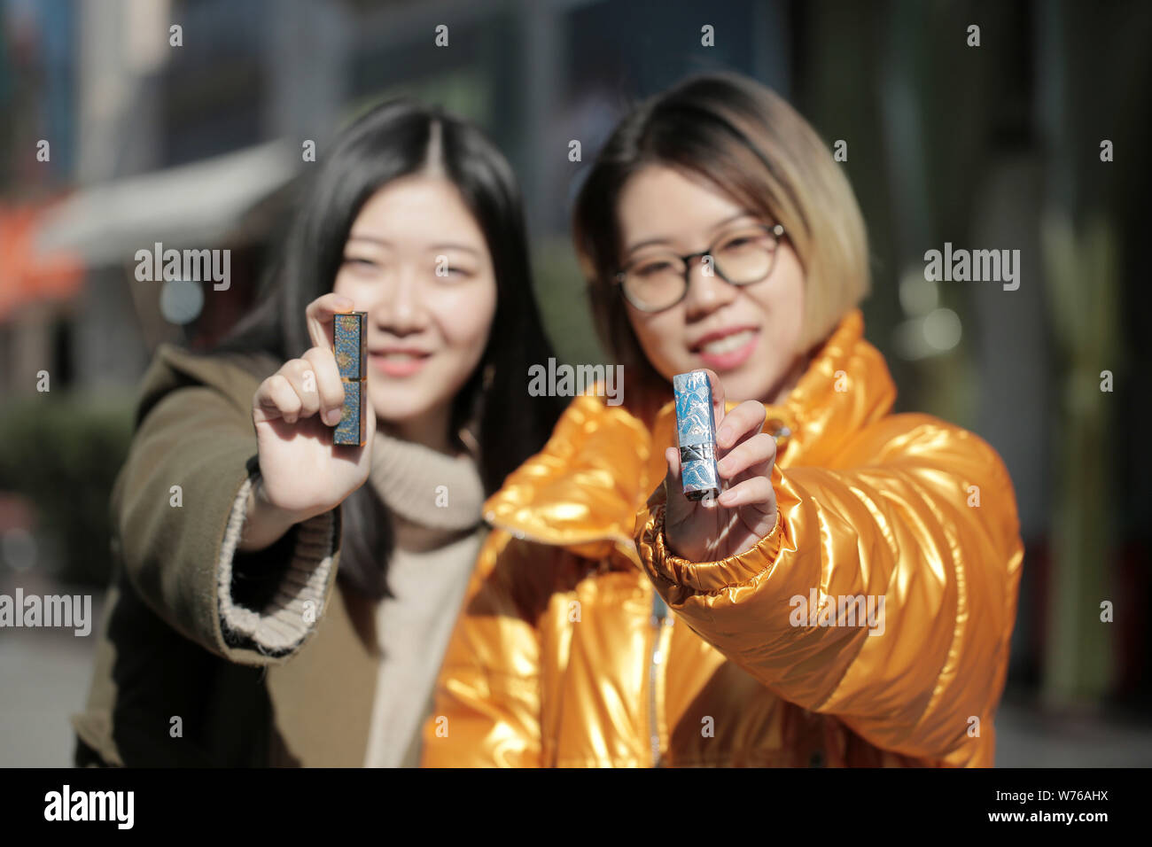 I clienti mostrano il loro rossetti abbellita da Chinese Boy Xiao Tian dal Gongshang Zhejiang University con adesivi su strada in Hangzhou Foto Stock