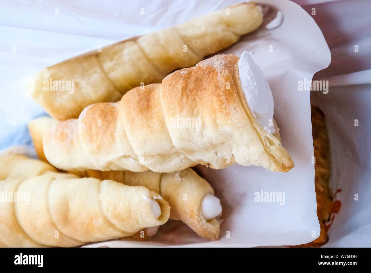 Il dessert, il tubo con la crema. Pasticceria nel pacchetto Foto Stock