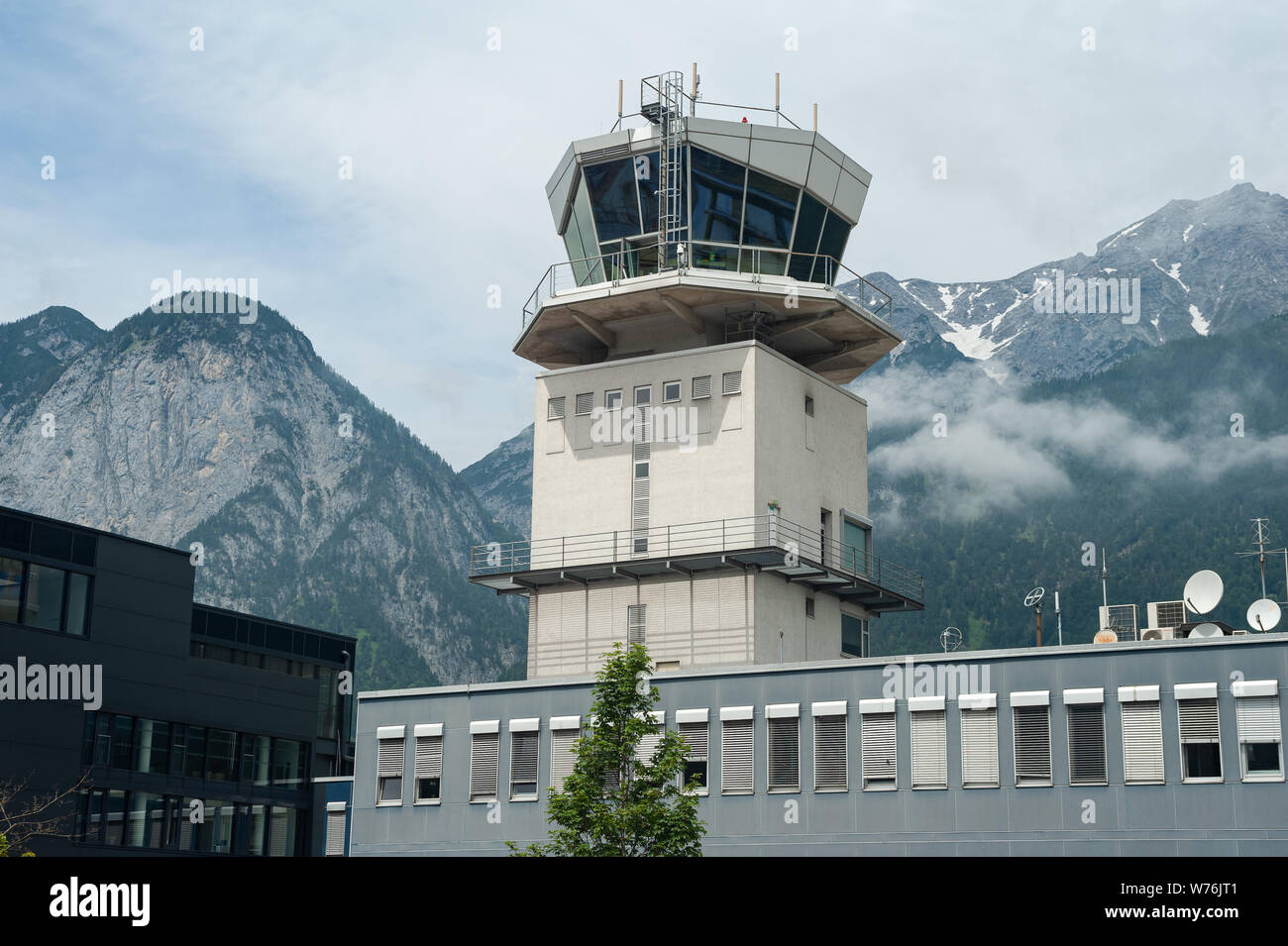 22.06.2019, Innsbruck, in Tirolo, Austria, Europa - vista esterna dall'aeroporto di Innsbruck con la torre di ATC e le montagne come sfondo. Foto Stock