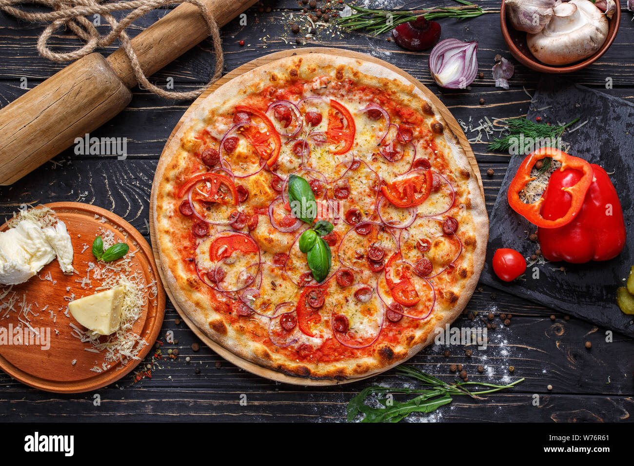 Pizza aromatica con salsicce da caccia, cipolle e pomodori Foto Stock
