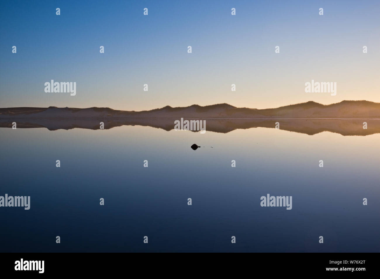 Cielo di tramonto riflettendo in acque calme. Bertha's Beach, East Falkland Foto Stock
