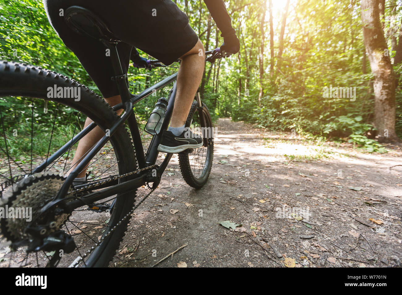 Gambe di uomo caucasico equitazione bicicletta nella foresta Foto Stock