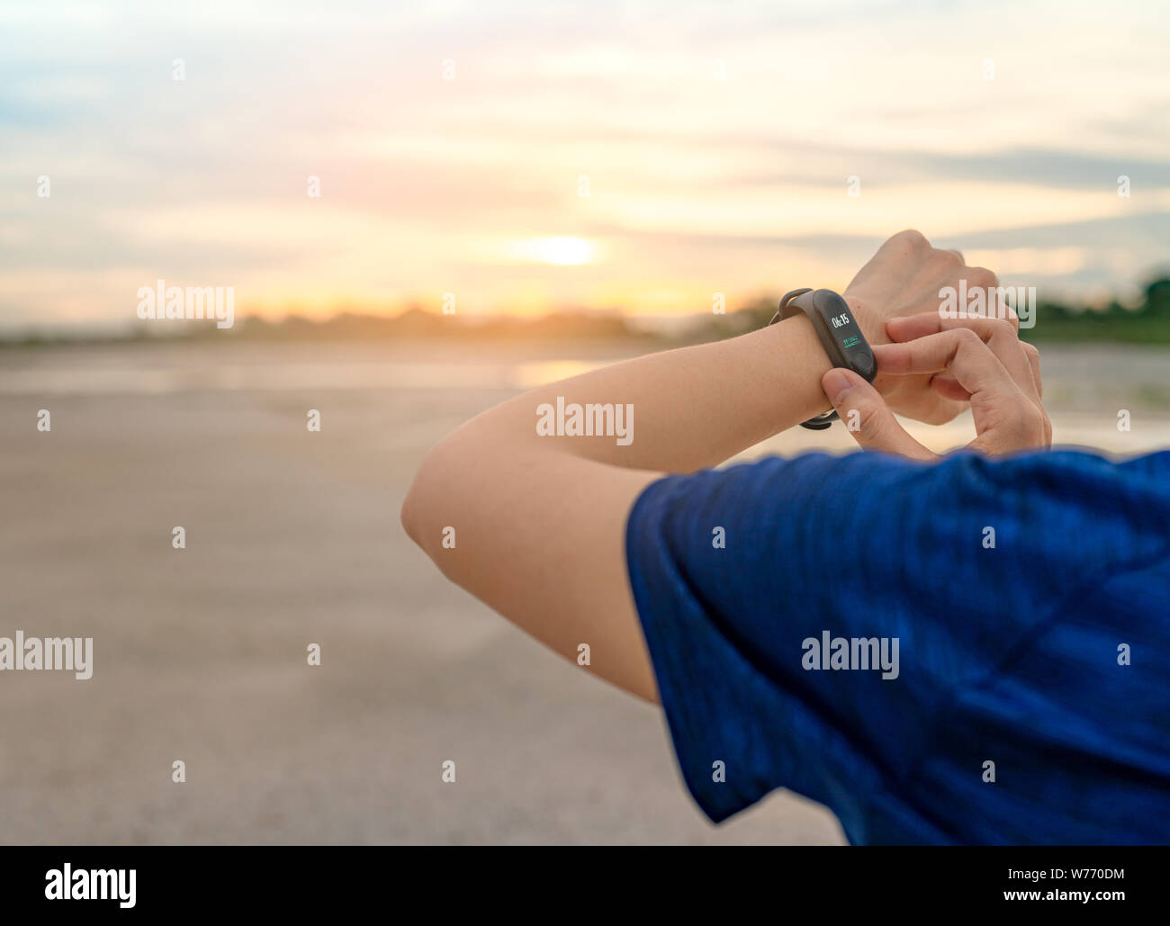 Giovane donna asiatica toccando smart band dopo aver eseguito la mattina. Computer indossabile. Monitor frequenza cardiaca bracciale. Dispositivo Fitness. Attività o montare Foto Stock