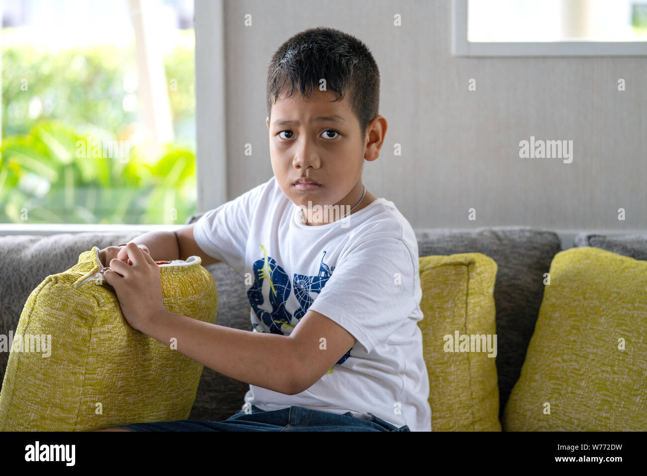 Khaoak, Thailandia, 20 luglio 2019: Asian giovane uomo seduto sul divano. Ansiosa attesa, ansioso. Foto Stock