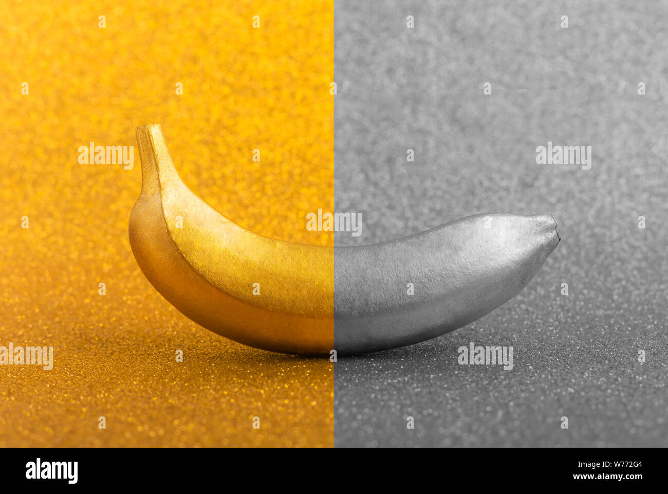 Il colore oro cibo, golden e silver banana in bright glitter o shimmer sfondo. Tropical Trendy concetto creativo, orietntation orizzontale Foto Stock