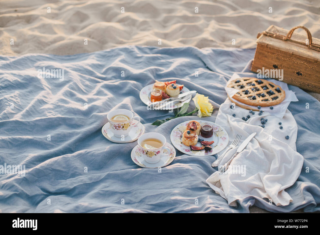 Splendido picnic con pancake, marmellata, American Pie e tè sul tramonto al mare. Foto Stock