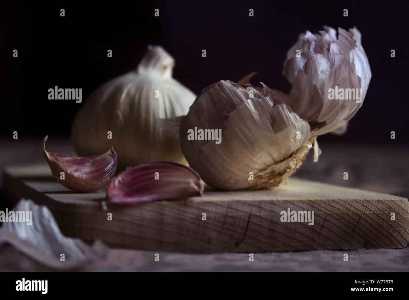 Capi di aglio su un tagliere Foto Stock